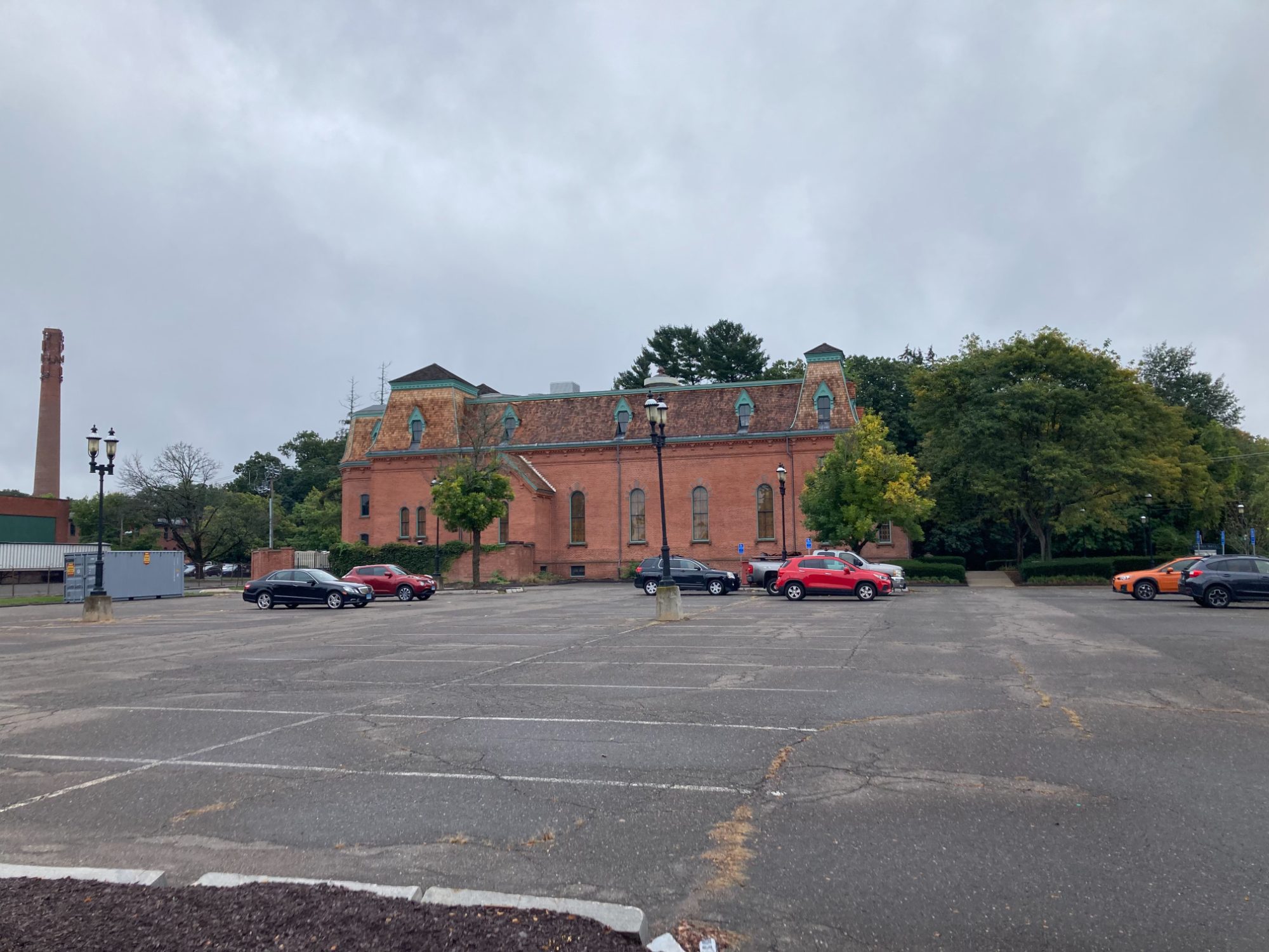 Cheney Hall within the historic Cheney Brothers mill district, with the mill chimney beyond