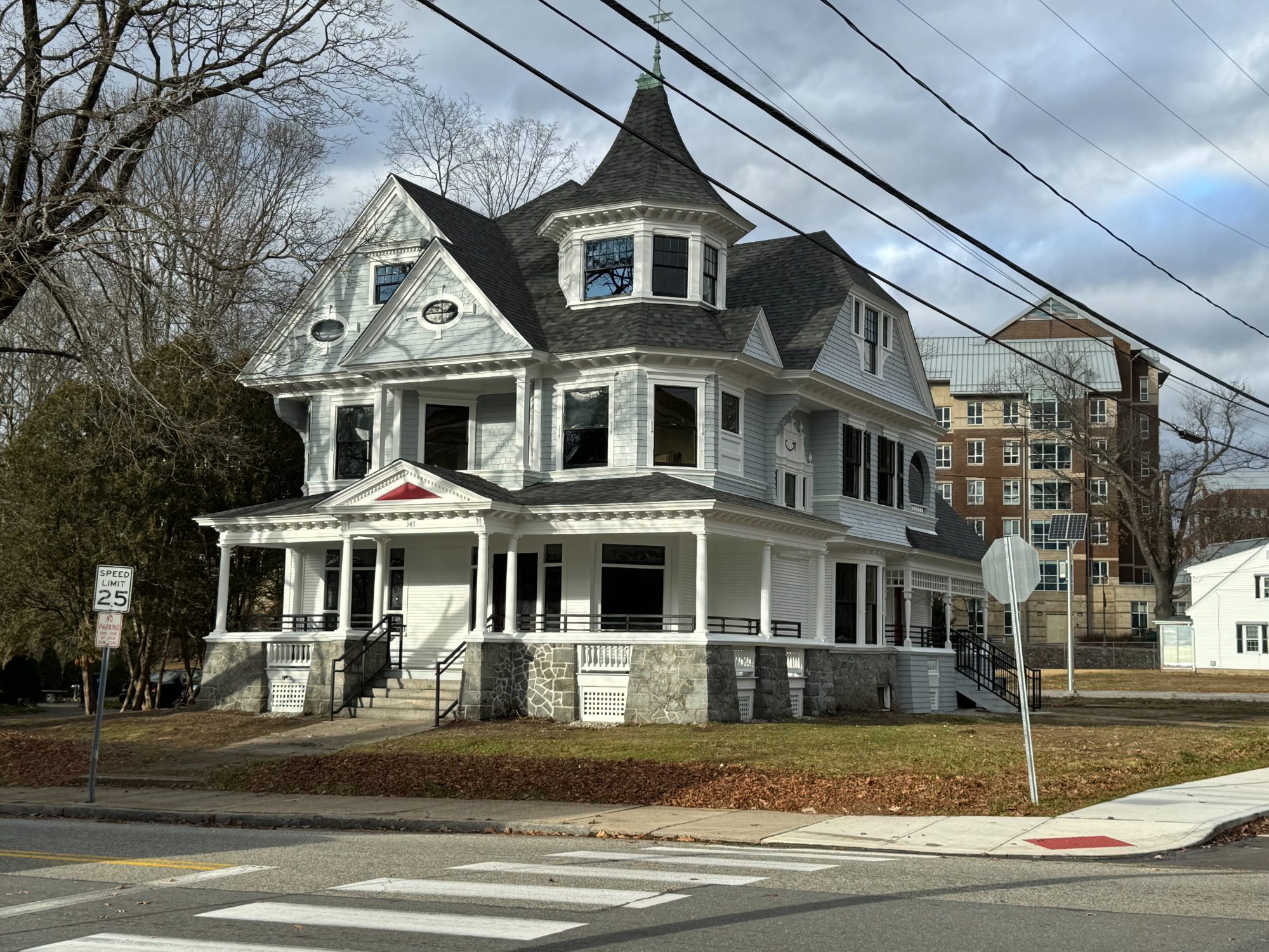 The restored 347 Prospect Street from the street corner: white clapboard and shingle siding, turret, and wraparound porch