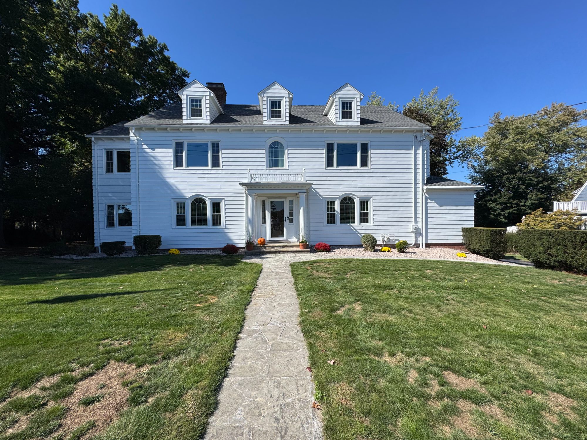 Front facade of the restored Wallingford mansion with new windows, roof and dormers, seen from the front walk