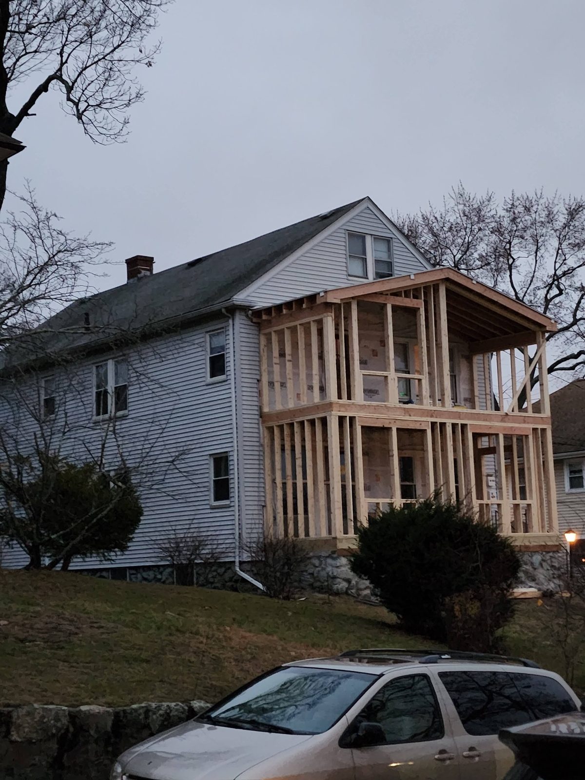 Two-story wood framing for the new front addition against the existing house