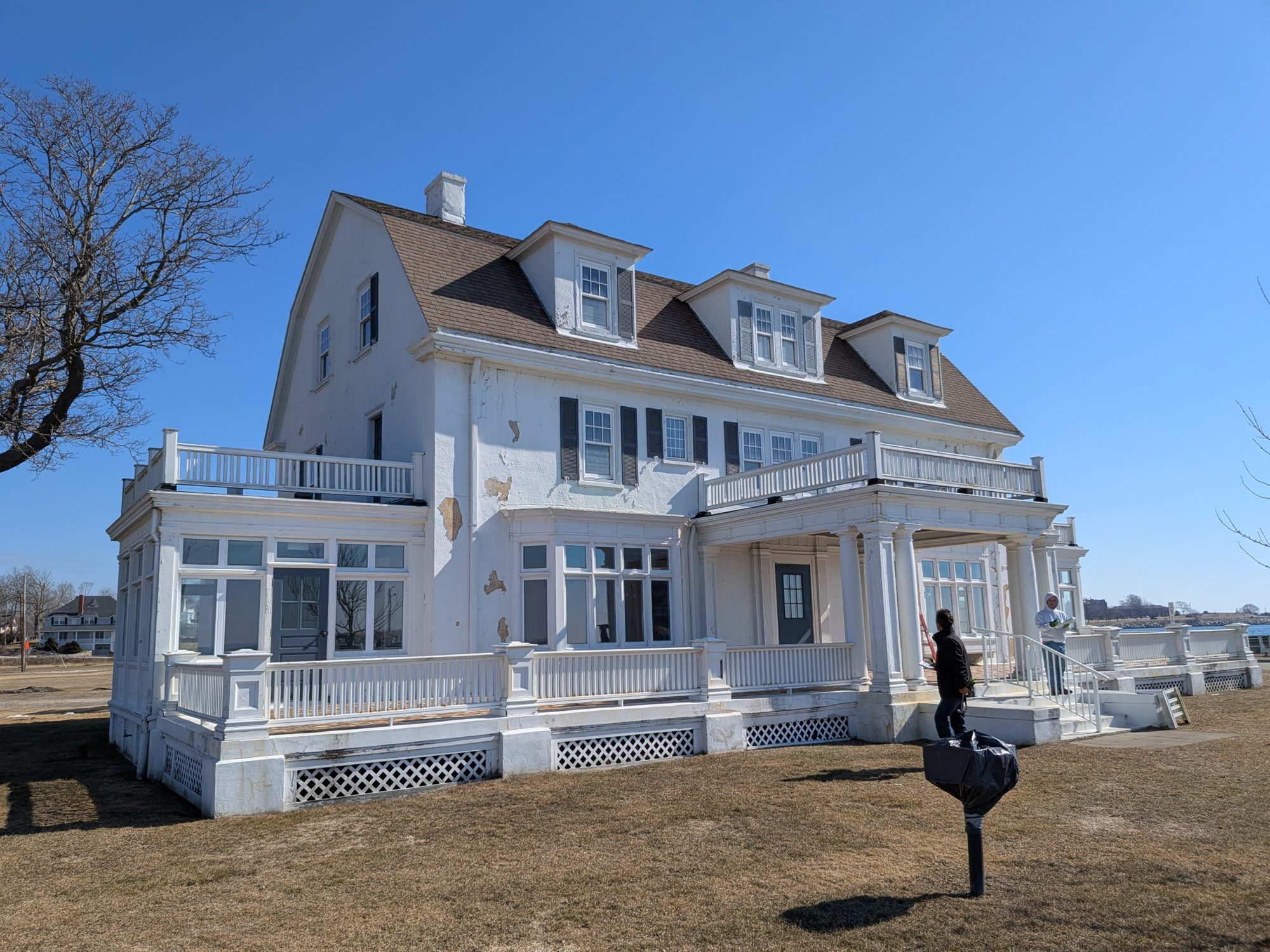The Zbierski House before restoration, with peeling paint and failed stucco coating across the walls, dormers and porch